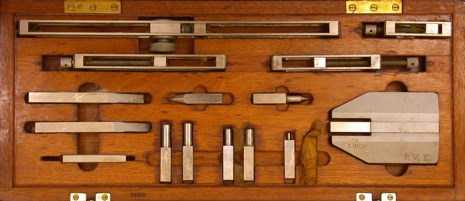 Gauge-block holders, scribers, and measuring accessories fitted into a wooden case.