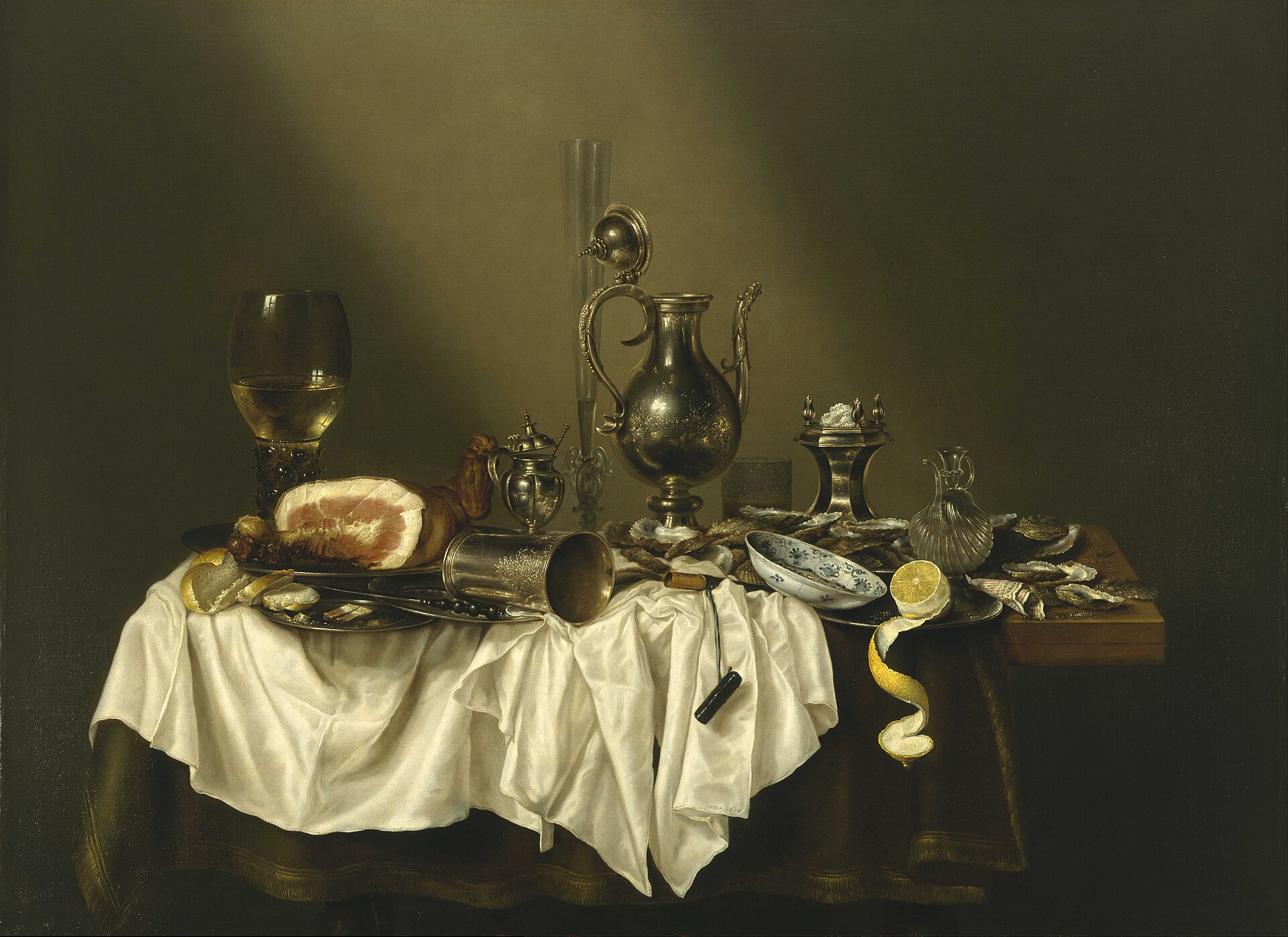 Dutch still-life painting of a banquet table with a ham, gleaming silver pitcher, pewter plates, glassware, and a rumpled white cloth.