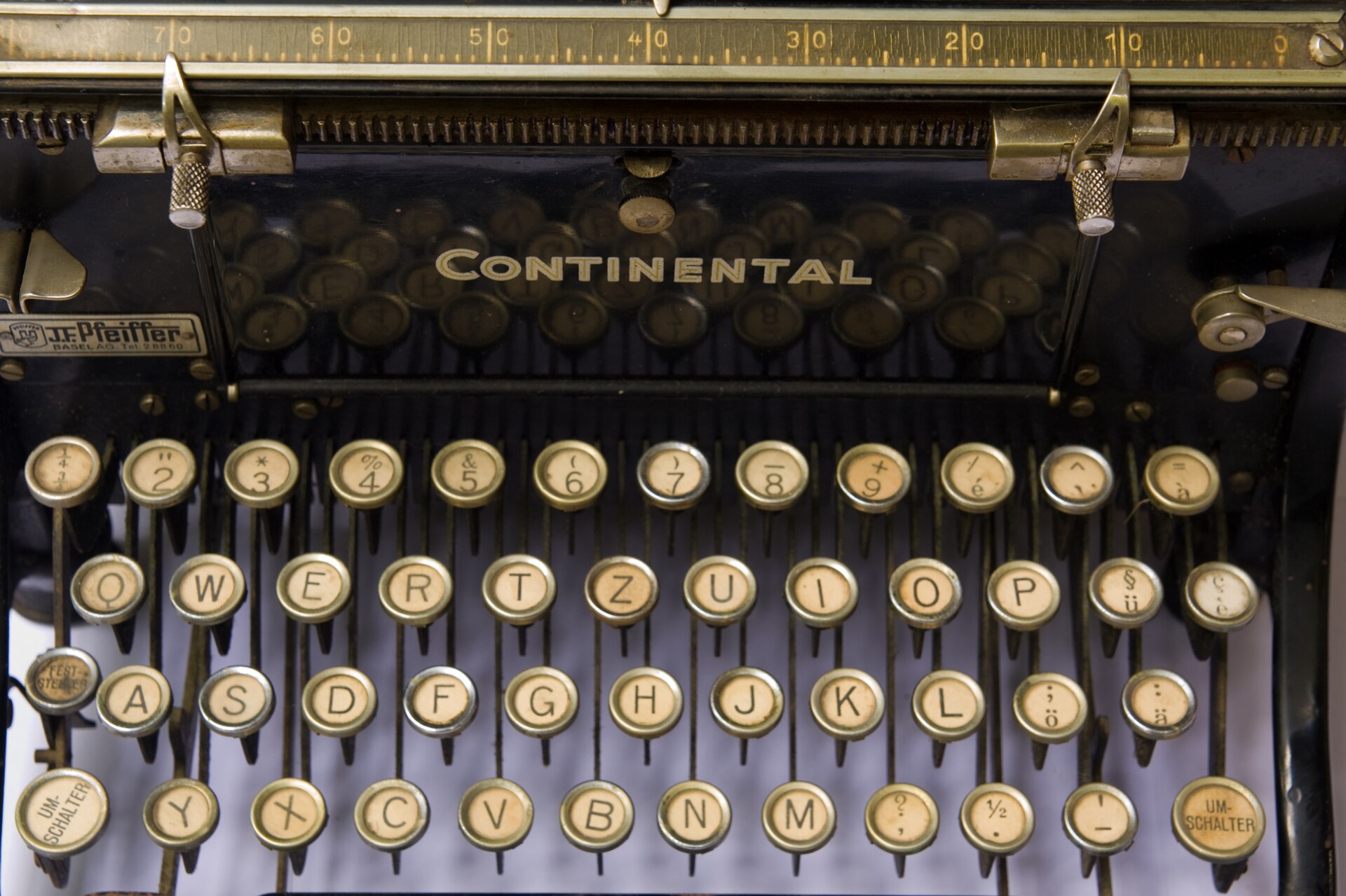 Close-up of the round black keys of a vintage Continental Standard typewriter keyboard.