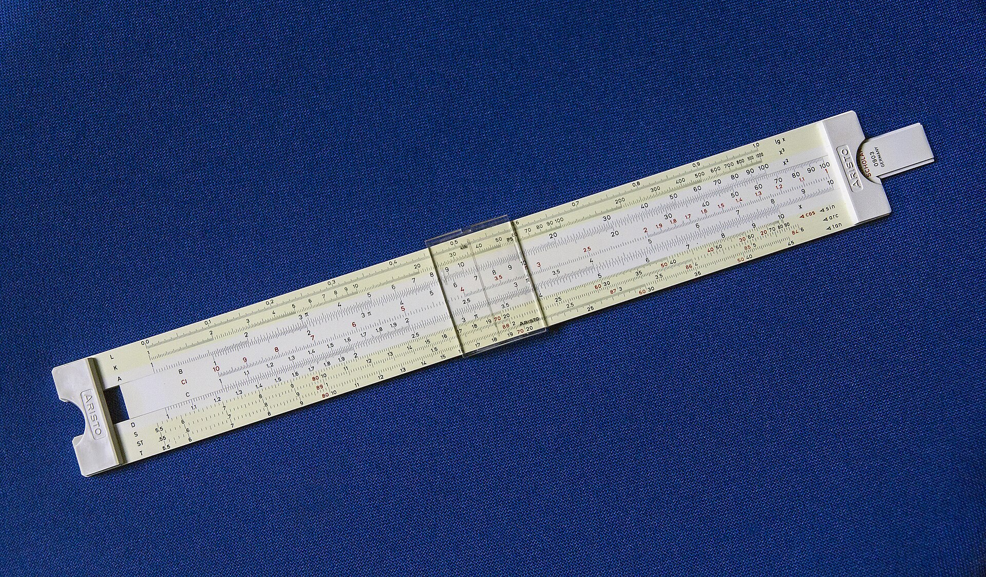 An Aristo Scholar slide rule with a movable center strip and transparent cursor.