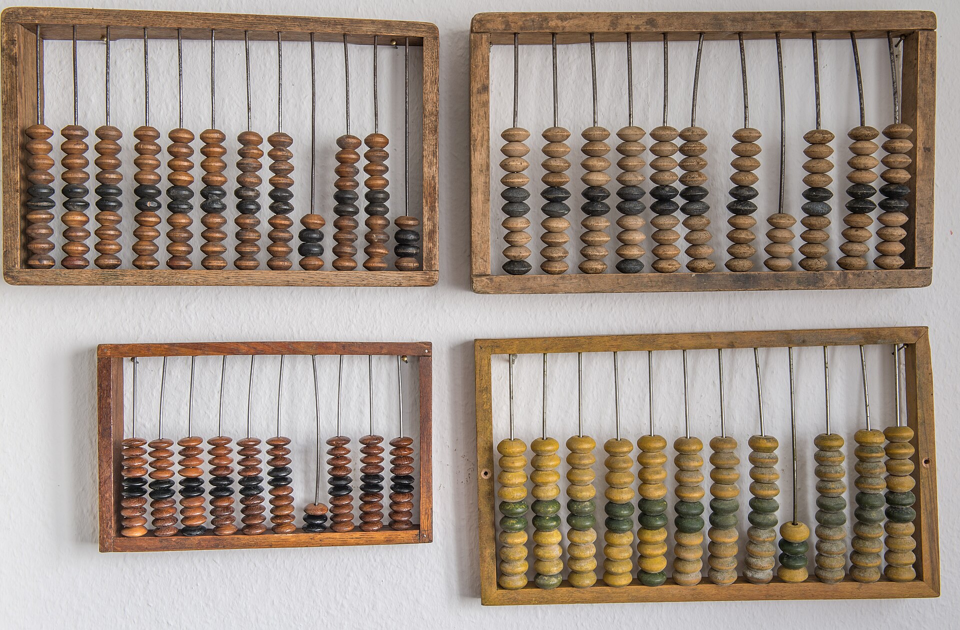 Four wooden abacuses with rows of beads on rods.