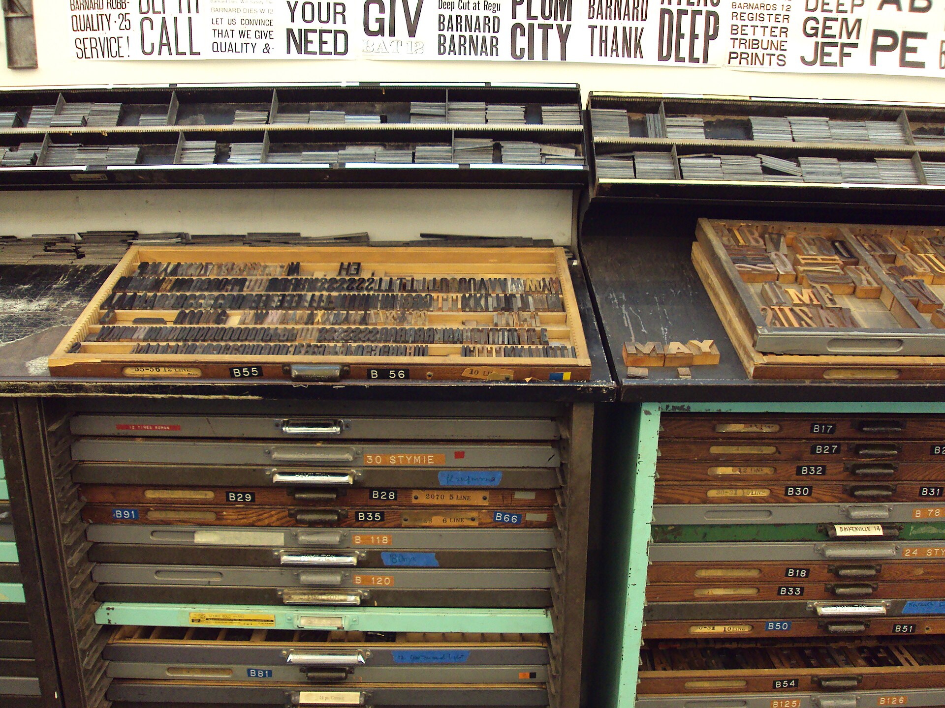 Open drawers of metal and wooden letterpress type in a printing workshop.